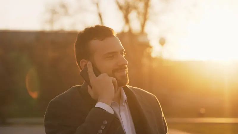 Homme souriant en appel sur son smartphone